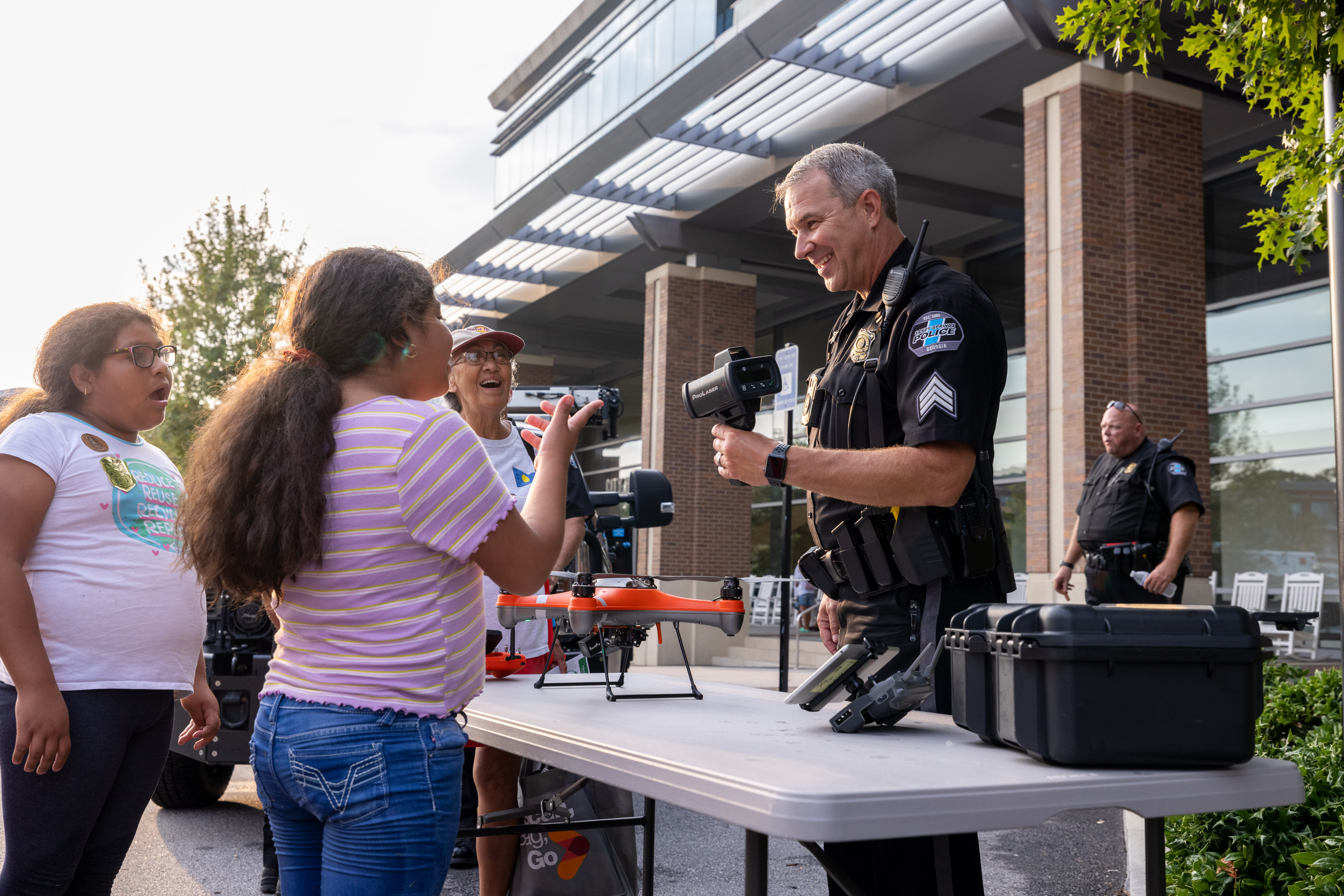 A Police Officer demonstrates police equipment to a family.