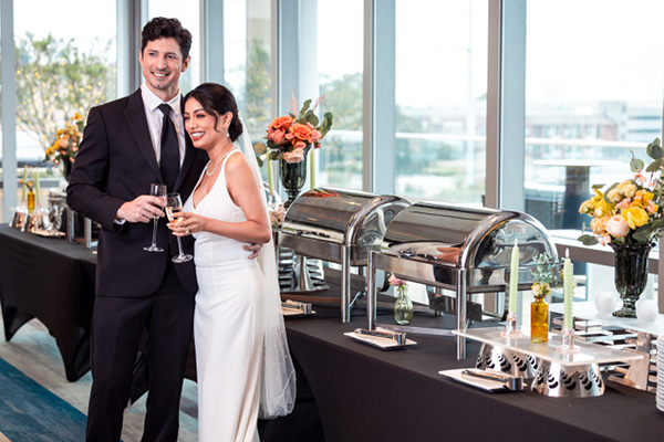 The happy bride and groom at the buffet in Terrace Room, overlooking City Green