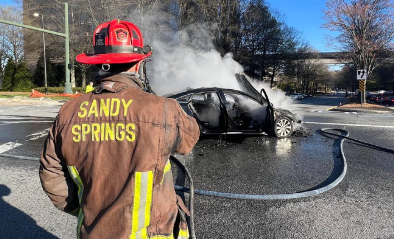 Fire fighter extinguishes a vehicle fire